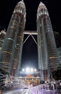 Illuminated modern buildings against sky at night