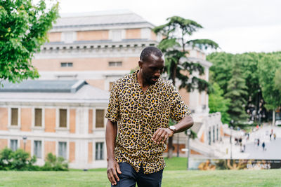 Man standing by tree against building