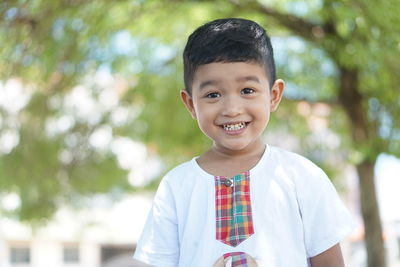 Portrait of smiling boy standing outdoors