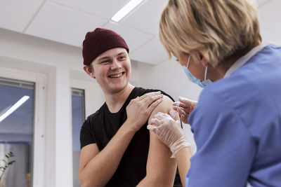 Smiling young man getting vaccinated against covid-19