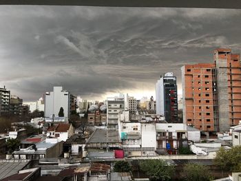 View of cityscape against cloudy sky