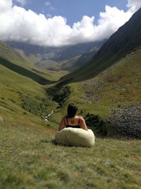 Young woman in front of grassy valley