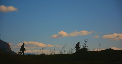 Silhouette woman on field against sky during sunset