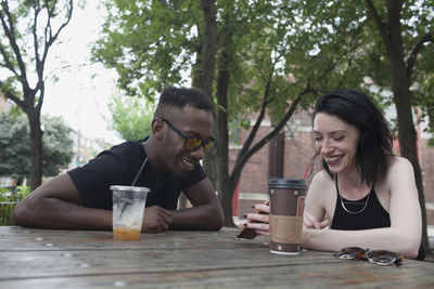 A young man and a young woman at a picnic table.