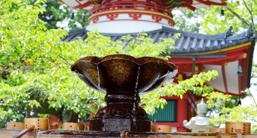 Low angle view of statue by building against trees