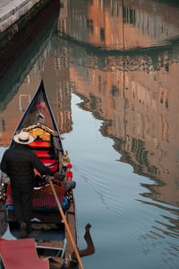 High angle view of men on gondola sailing in canal