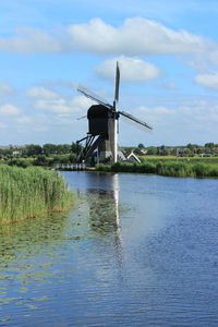 Traditional windmill on field against sky