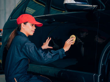 Woman cleaning car at auto repair garage