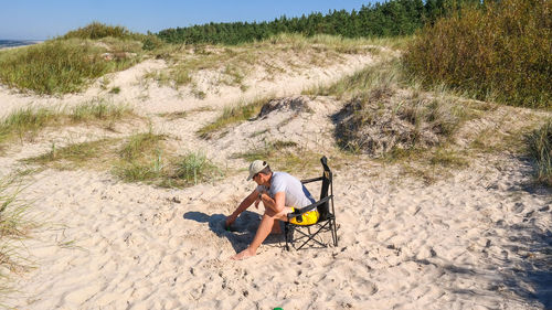 Man sitting on sand at beach