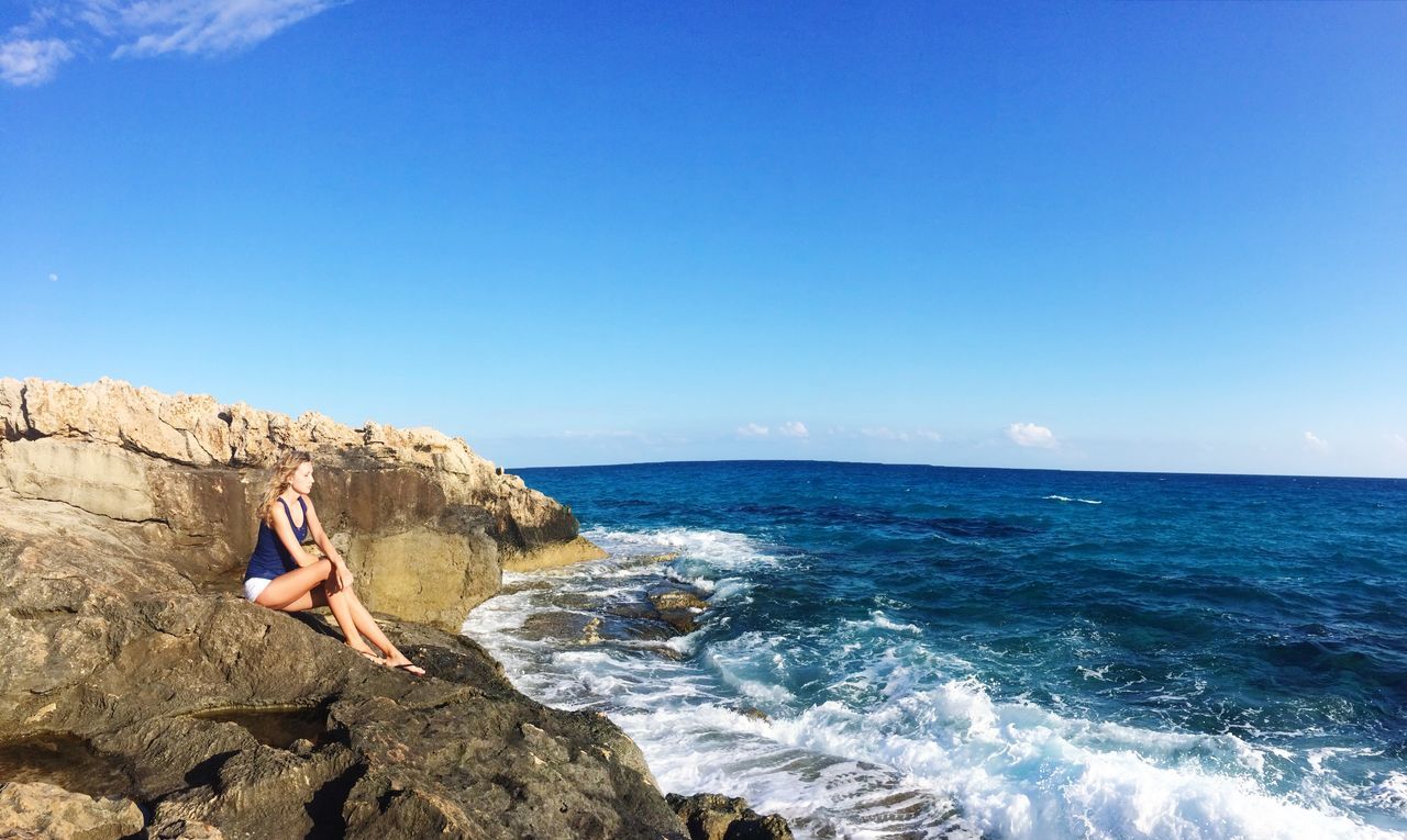 sea, horizon over water, water, rock - object, beauty in nature, scenics, beach, rock formation, rock, shore, clear sky, tranquility, nature, tranquil scene, sky, wave, copy space, cliff