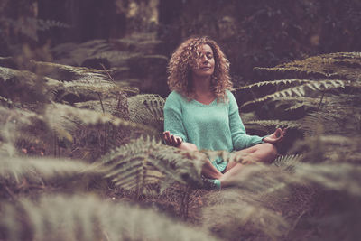 Portrait of young woman sitting on field