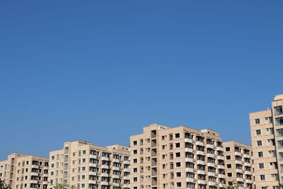 Low angle view of buildings against clear blue sky