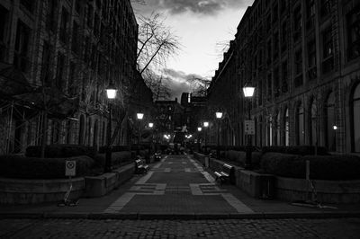 Street amidst buildings in city at night