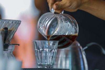 Close-up of hand pouring wine in glass