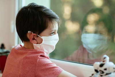 Boys wearing flu mask while studying at home