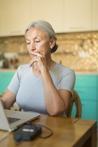 Portrait of senior woman using laptop