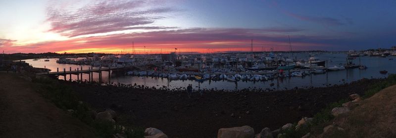 Boats in harbor at sunset