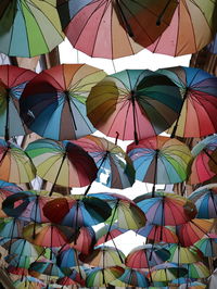 Low angle view of multi colored umbrellas hanging at market stall
