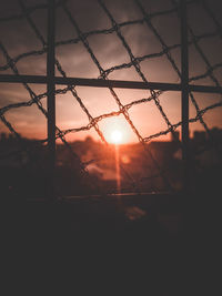 Close-up of silhouette fence against sunset sky