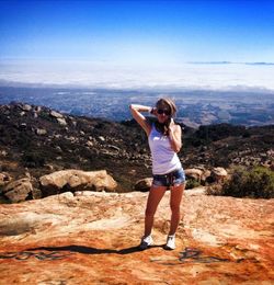 Portrait of a young woman standing on mountain