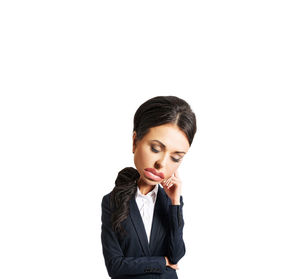 Tired businesswoman standing against white background