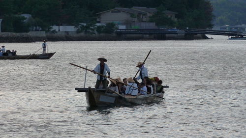 People in boat against river