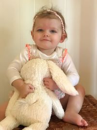 Portrait of cute baby girl sitting at home