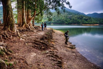 People standing by lake