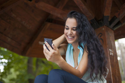 Smiling young woman using mobile phone
