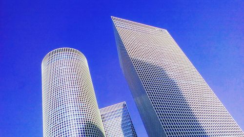 Low angle view of modern buildings against blue sky