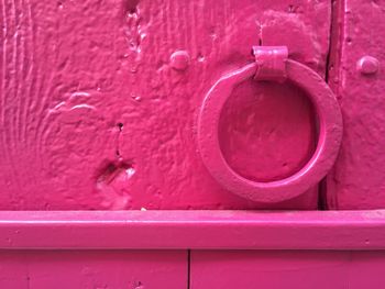 Close-up of pink metallic ring knocker on door