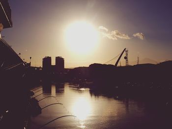 Silhouette bridge over river against sky during sunset