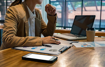 Midsection of man using laptop on table