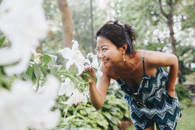 Young woman standing by flowering plants