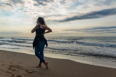 Full length of man standing on beach against sky