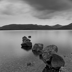 Rocks in lake against sky