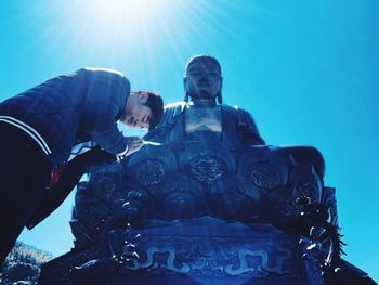 Low angle view of a man against blue sky