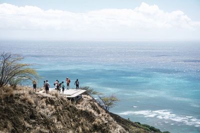 People standing on beach against sky