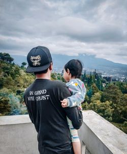 Father and daughter standing looking at the natural landscape