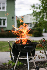 Fire burning on barbecue grill at yard