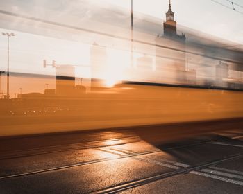 Train at railroad station against sky during sunset