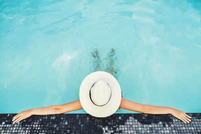 High angle view of woman relaxing in swimming pool