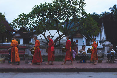 Rear view of people walking in front of building