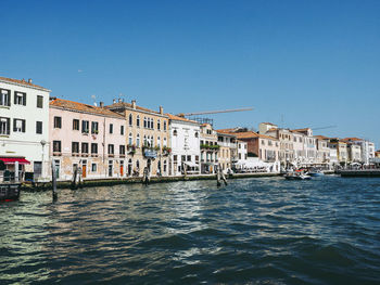 Canal against buildings in city on sunny day