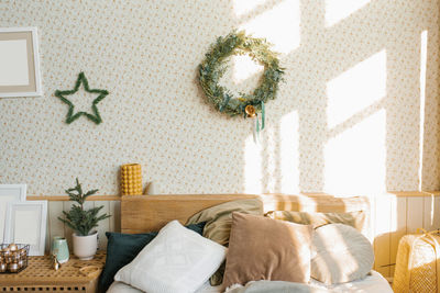 A bed with pillows and christmas decorations in the bedroom in a scandinavian style.