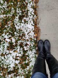 Low section of person standing on snow