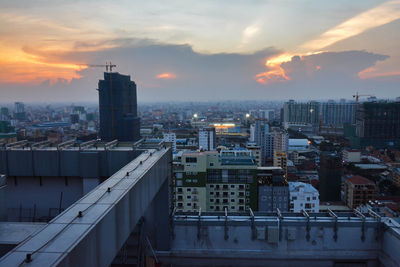 Modern buildings in city against sky during sunset