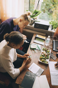 Rear view of couple sitting on table at home