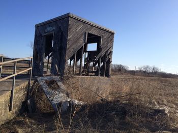 Abandoned house on field against clear sky