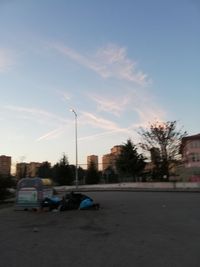 Cars on street by buildings against sky